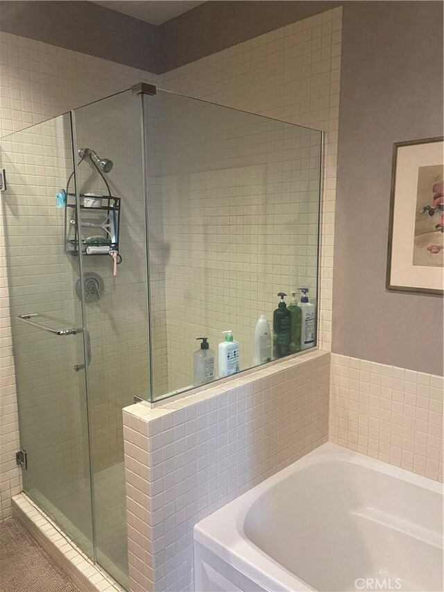 bathroom with shower with separate bathtub and tile patterned floors