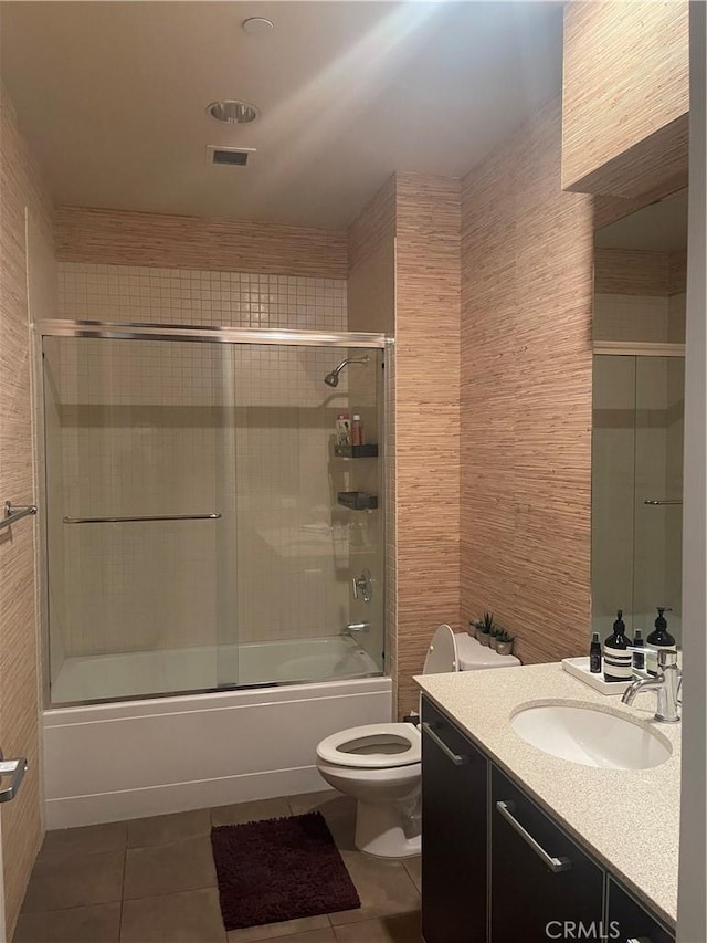 full bathroom with toilet, tile patterned flooring, enclosed tub / shower combo, and vanity