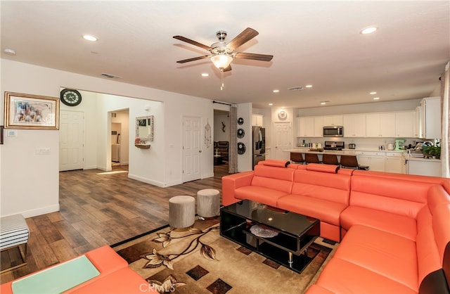 living room with hardwood / wood-style flooring and ceiling fan