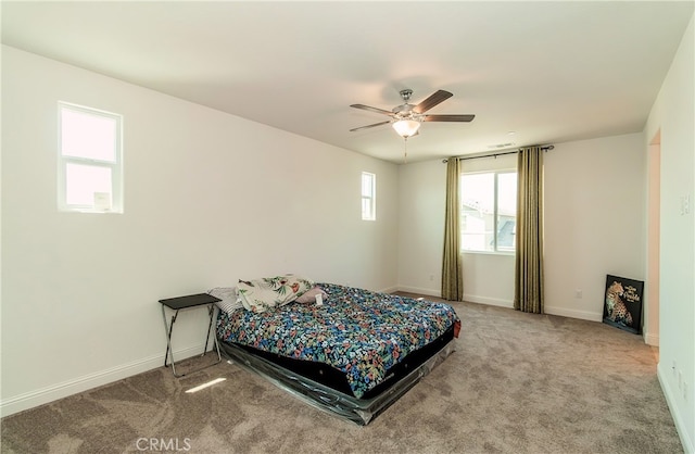 carpeted bedroom with ceiling fan and multiple windows