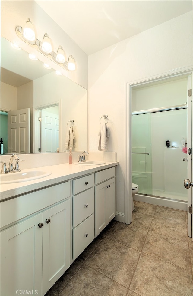 bathroom with vanity, toilet, tile patterned flooring, and an enclosed shower