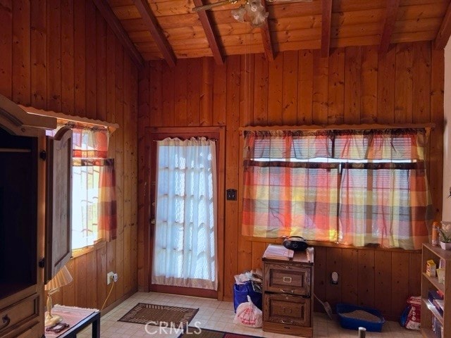 entryway featuring wood ceiling, wooden walls, beam ceiling, and light tile patterned floors