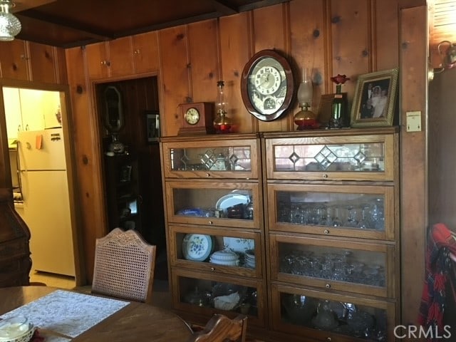 interior space with wooden walls and white fridge