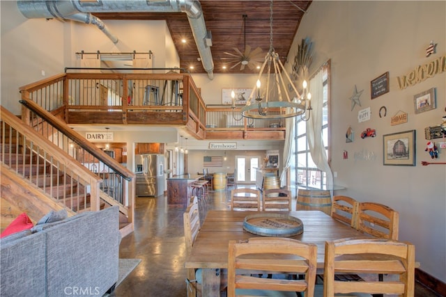 dining room featuring beamed ceiling, a notable chandelier, and a towering ceiling