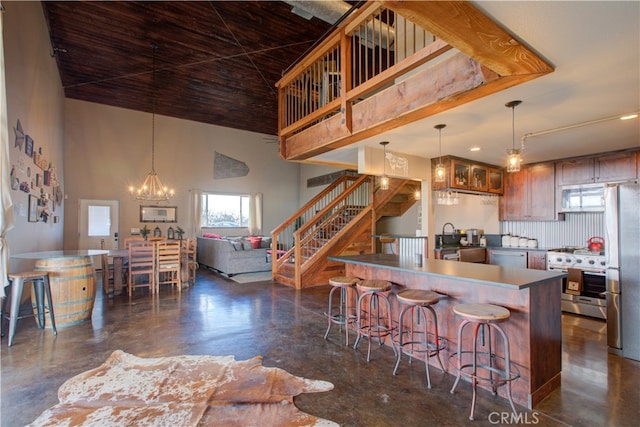 kitchen with tasteful backsplash, sink, stainless steel appliances, pendant lighting, and a notable chandelier