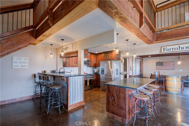 kitchen featuring kitchen peninsula, high quality appliances, a breakfast bar, and pendant lighting