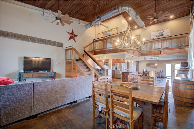 dining room featuring wood ceiling, a towering ceiling, and ceiling fan with notable chandelier