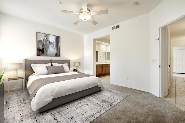 carpeted bedroom featuring ensuite bath and ceiling fan