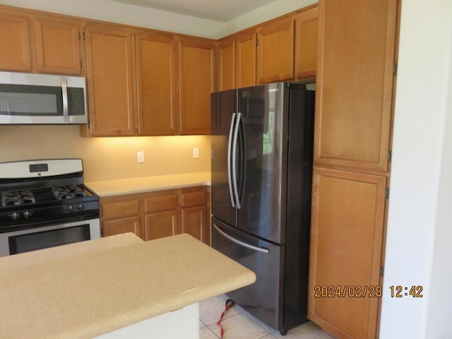 kitchen with appliances with stainless steel finishes and light tile patterned floors