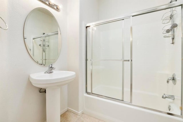 bathroom with tile patterned floors and shower / bath combination with glass door