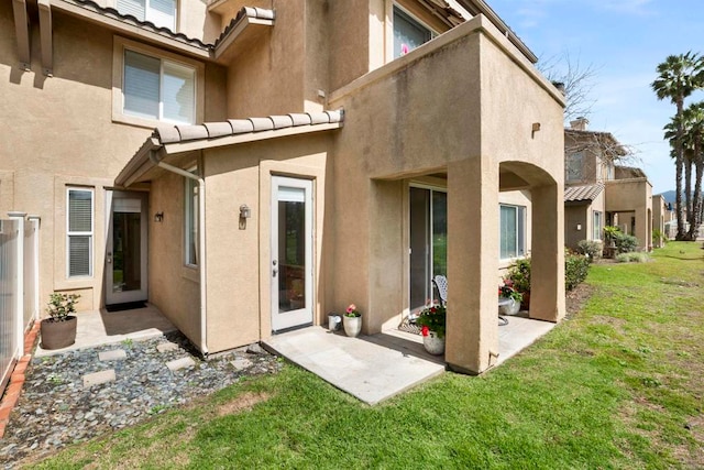 rear view of property with a yard and a patio area