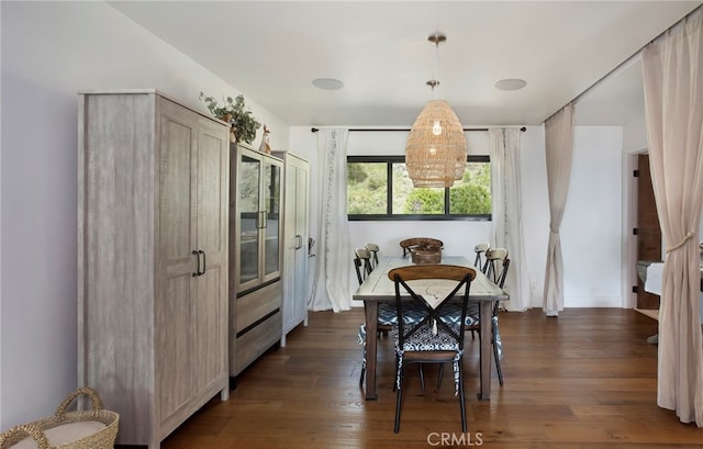 dining area featuring dark wood-type flooring and a notable chandelier