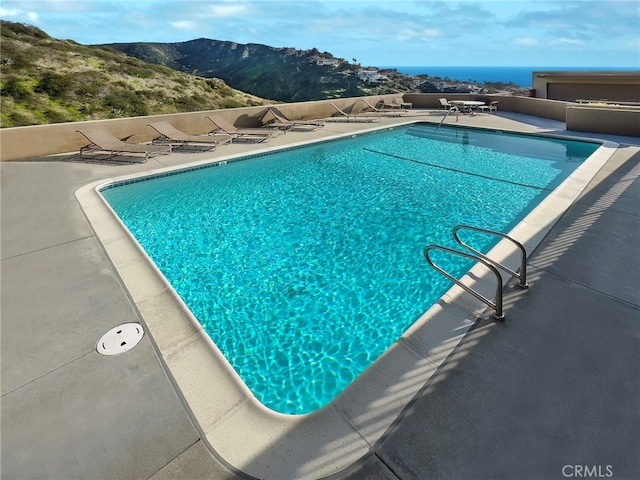 view of pool featuring a mountain view and a patio