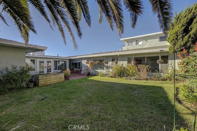 rear view of property featuring a lawn