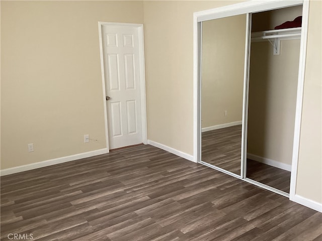 unfurnished bedroom with a closet and dark hardwood / wood-style flooring