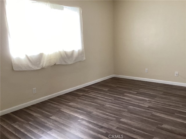 unfurnished room with dark wood-type flooring