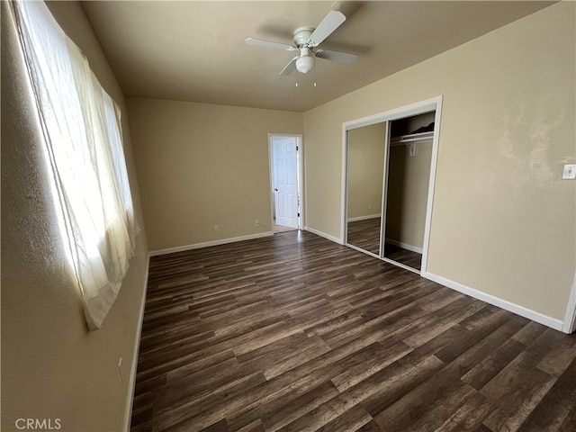 unfurnished bedroom with dark hardwood / wood-style flooring, a closet, and ceiling fan