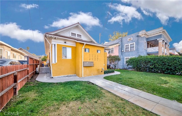 rear view of house with a yard and a balcony