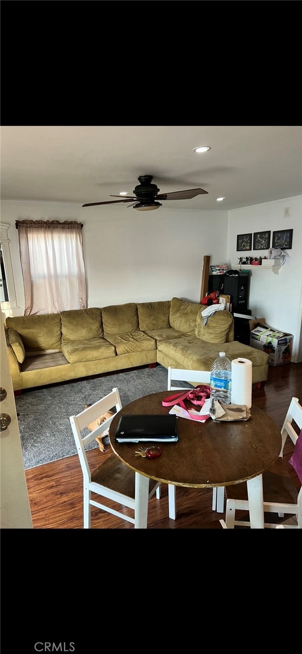 living room featuring hardwood / wood-style floors and ceiling fan