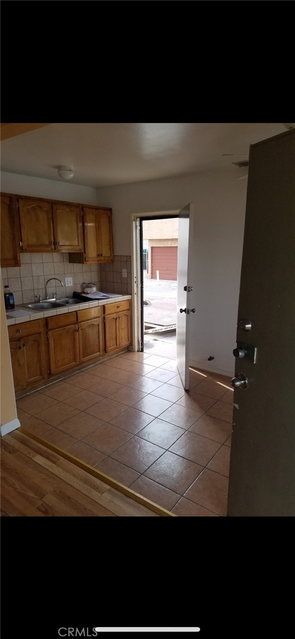 kitchen featuring sink, light hardwood / wood-style floors, and backsplash