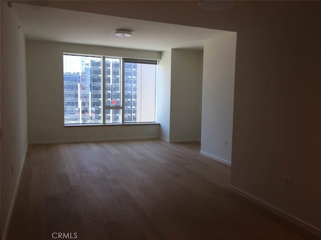 unfurnished room featuring dark wood-type flooring