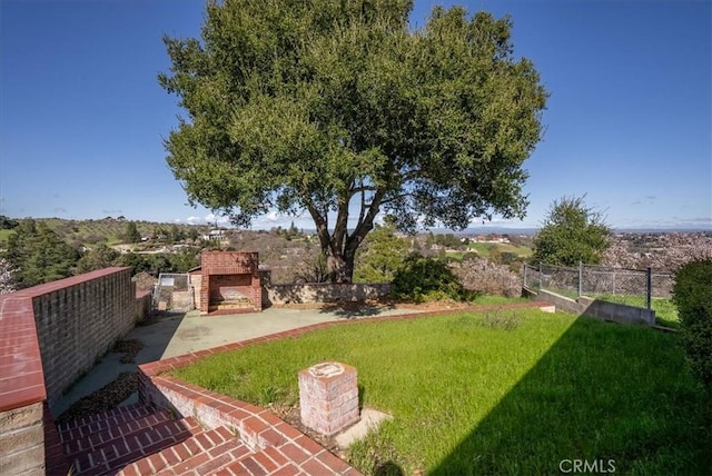 view of yard featuring an outdoor stone fireplace and a patio