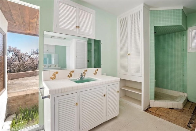 bathroom with vanity and tiled shower