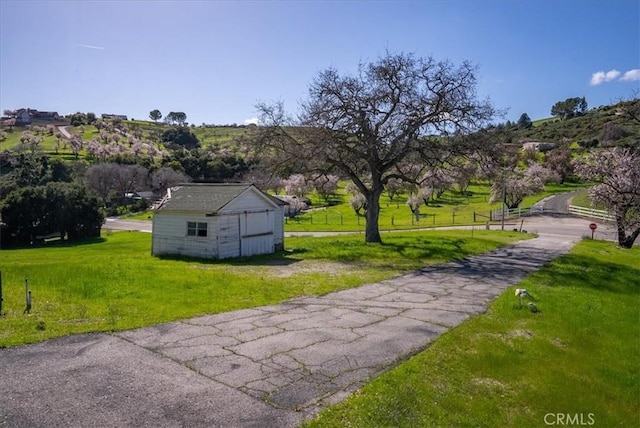 surrounding community featuring an outbuilding and a yard