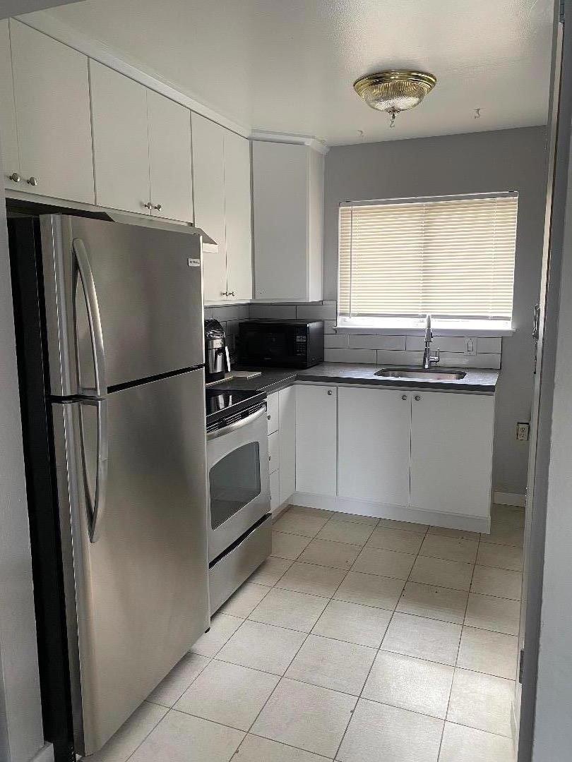 kitchen with white cabinetry, stainless steel appliances, and sink