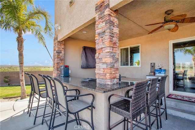 view of patio / terrace with exterior bar and ceiling fan