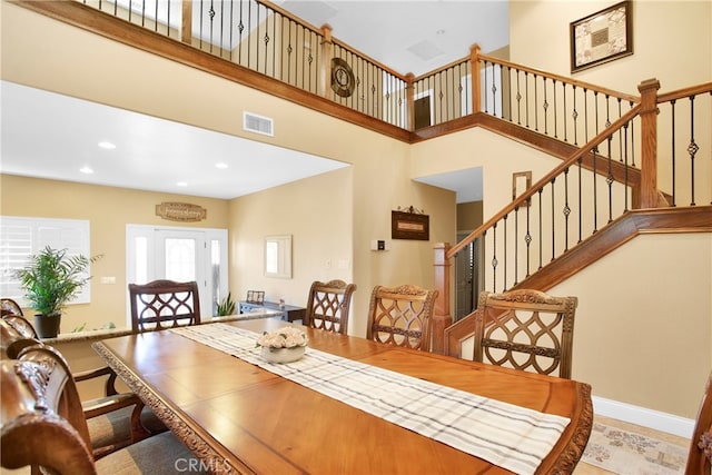 dining space featuring a towering ceiling