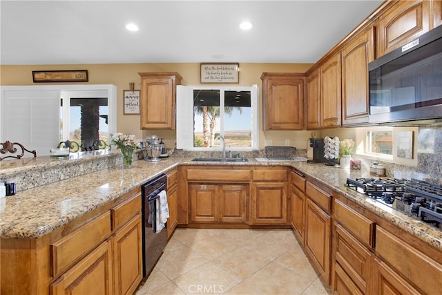 kitchen with light stone countertops, appliances with stainless steel finishes, light tile patterned floors, and sink