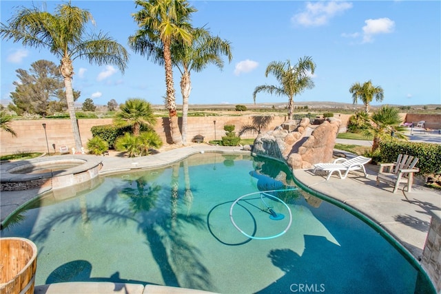 view of swimming pool featuring a patio and an in ground hot tub