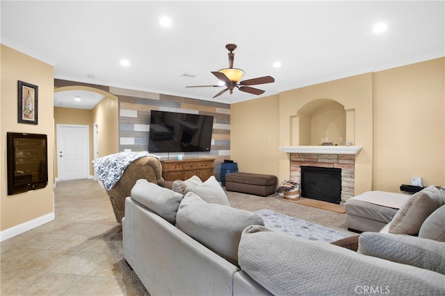 living room with ornamental molding, ceiling fan, light tile patterned floors, and a fireplace