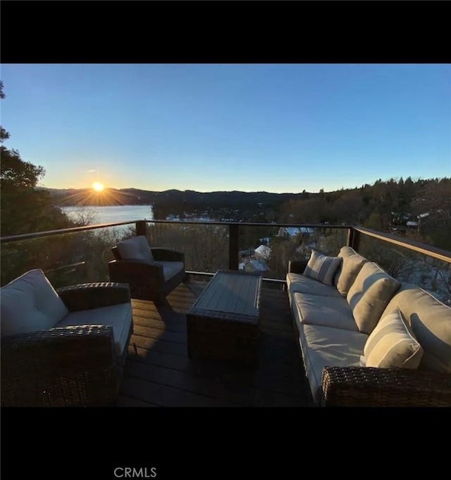 deck at dusk featuring a mountain view and an outdoor living space