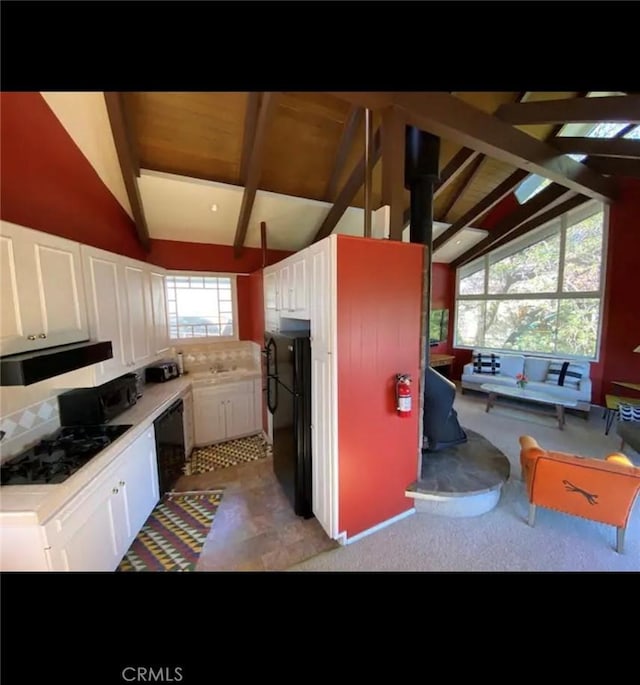 kitchen with white cabinets, black appliances, range hood, and vaulted ceiling with beams