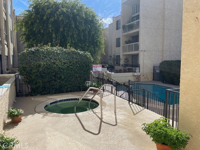 view of pool with a hot tub