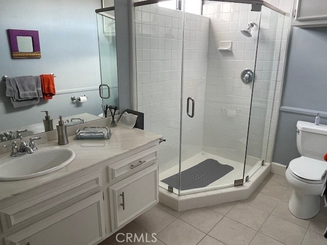 bathroom with tile patterned floors, walk in shower, vanity, and toilet