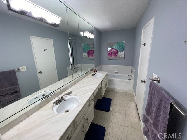 bathroom featuring vanity, tile patterned floors, and a relaxing tiled tub