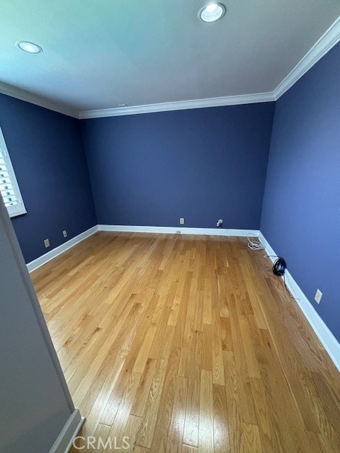 spare room with hardwood / wood-style floors and crown molding