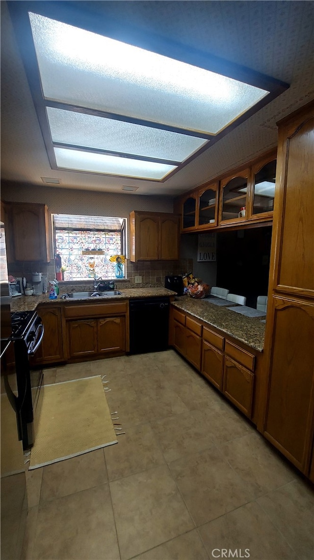 kitchen with sink, black appliances, light tile patterned floors, and tasteful backsplash