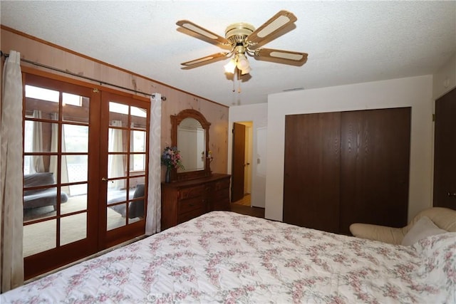 unfurnished bedroom with french doors, a textured ceiling, a closet, and ceiling fan