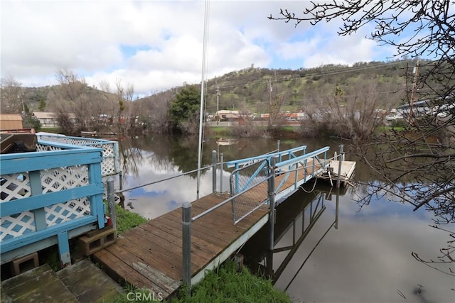 view of dock with a water and mountain view