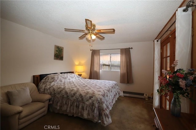 bedroom with ceiling fan, dark colored carpet, a textured ceiling, and a baseboard heating unit