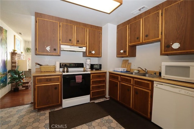 kitchen with wood-type flooring, white appliances, and sink