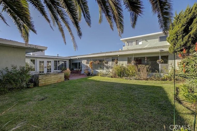 rear view of property with a yard