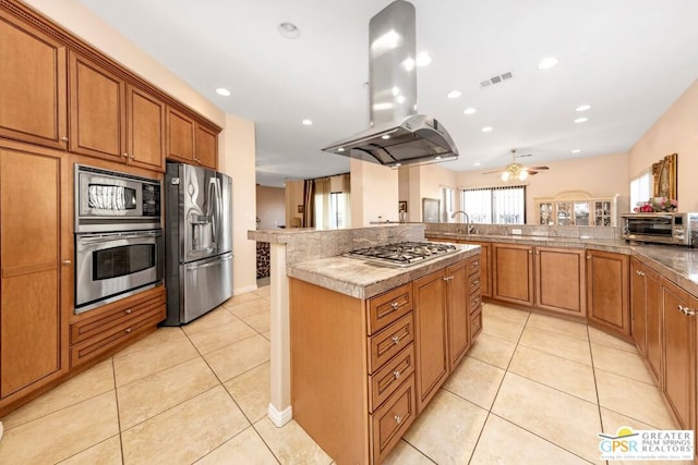 kitchen with ceiling fan, light tile patterned floors, appliances with stainless steel finishes, a kitchen island, and island exhaust hood