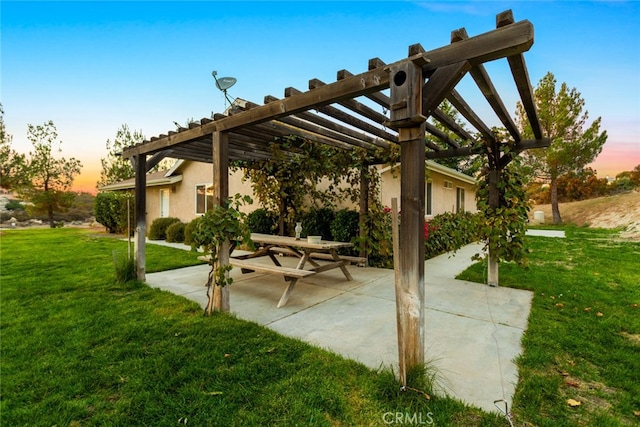 patio terrace at dusk with a lawn and a pergola