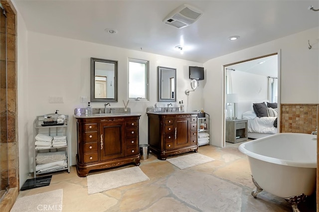 bathroom with vanity, a washtub, and tile walls