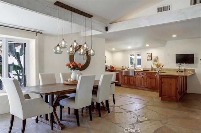 dining room featuring sink and vaulted ceiling